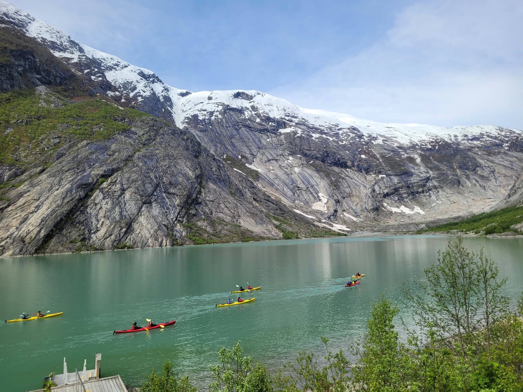 Kajakkpadlarar på eit grønt brevatn under breen